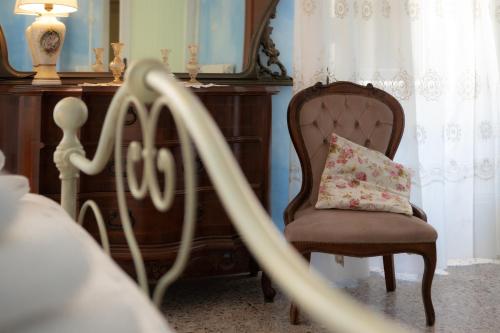 a chair with a pillow sitting next to a dresser at La Casa del Gelsomino in Acquaviva Picena