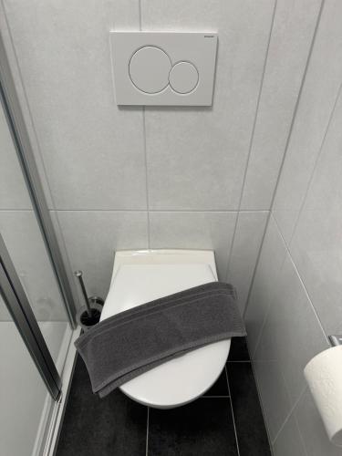 a bathroom with a toilet with a towel on it at Hotel Lijo, bei Basel in Steinen