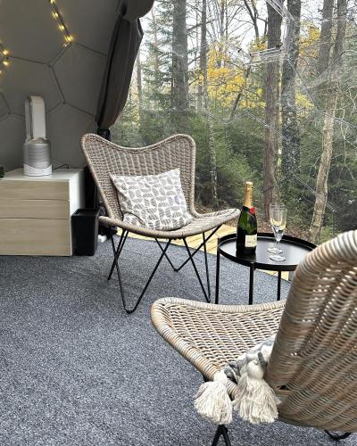 a room with two chairs and a table with a bottle of wine at Gråbogården event and conference center in Gråbo