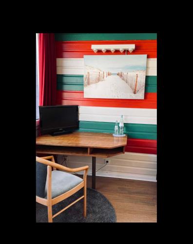a desk with a laptop and a chair in a room at Seehotel in Helgoland