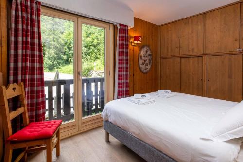 une chambre avec un lit et une grande fenêtre dans l'établissement Le Brevent 2 Apartment - Chamonix All Year, à Chamonix-Mont-Blanc