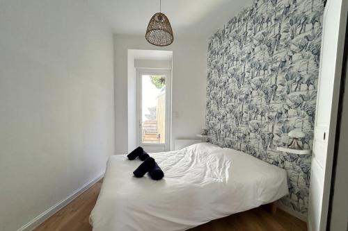 a bedroom with a bed with a teddy bear on it at Côté Plage - Plein centre de Binic in Binic-Etables-sur-Mer
