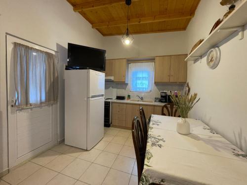 Una cocina con una mesa y un refrigerador blanco. en Lefakis cottage, en Órmos