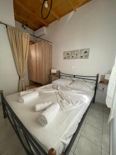 ein Schlafzimmer mit einem Bett mit weißen Laken und Handtüchern in der Unterkunft Lefakis cottage in Órmos