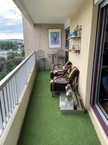 un balcon avec un sol vert et des chaises dessus dans l'établissement Havre de paix proche Paris, à Cachan