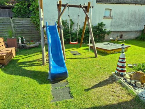 a playground with a blue slide in a yard at An der Unstrutquelle in Kefferhausen
