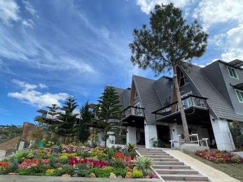 a house with a garden in front of it at บ้านผูกรัก ทะเลหมอก ณ เขาค้อ in Khao Kho