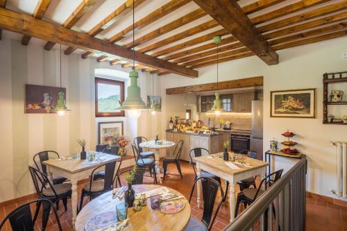 a dining room with tables and chairs and a kitchen at Foresteria Castello di Verrazzano in Greve in Chianti