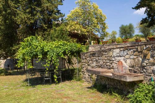 a stone wall with a bench in a yard at Foresteria Castello di Verrazzano in Greve in Chianti