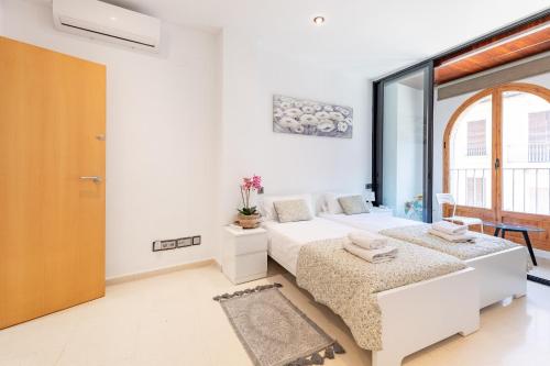 a bedroom with two beds and a large window at Aparthotel Mediterráneo by NeoHotels-Centro 8 min by Metro in Valencia