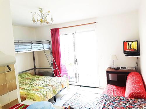 une chambre avec deux lits superposés et une fenêtre dans l'établissement Résidence des Deux Plages, à La Rochelle