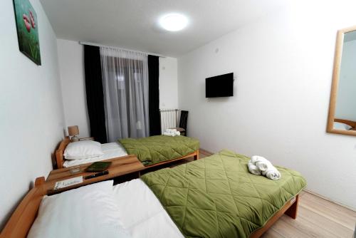 a small room with two beds and a television at Apartmani Smiljković90 in Aleksandrovac