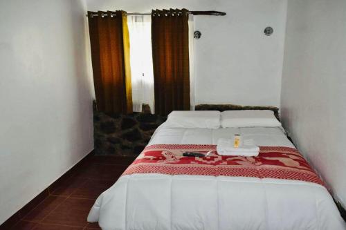a bedroom with a bed with a candle on it at Inca viewpoint in Ollantaytambo