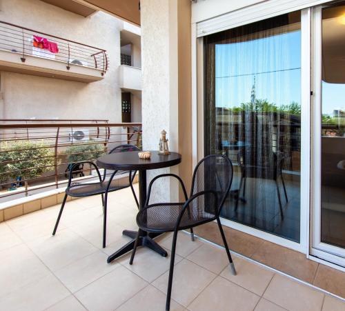 a patio with a table and chairs on a balcony at Ammolithos Beach in Stavros