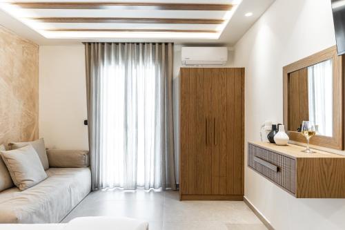 a living room with a couch and a window at Perla Hotel in Agios Prokopios