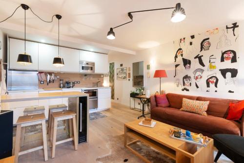 un salon avec un canapé et une cuisine dans l'établissement L'appart des Ducs - Vue sur la basilique à Nancy, à Nancy