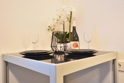 a table with two plates and a bottle of wine at Cosy new apartment in calm area near merano in Plaus