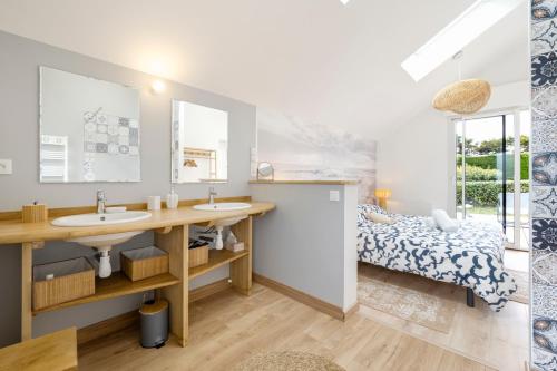 La salle de bains est pourvue de 2 lavabos et d'un lit. dans l'établissement Evasion Bord de Mer Criques & Côte sauvage, au Pouliguen