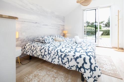 une chambre avec un grand lit avec une grande fenêtre dans l'établissement Evasion Bord de Mer Criques & Côte sauvage, au Pouliguen