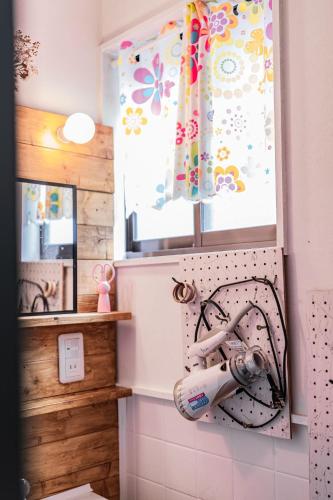 a bathroom with a hair dryer hanging on the wall at 易居の宿 in Osaka