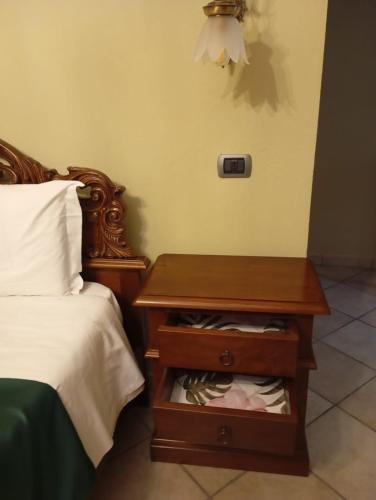 a bed with a wooden nightstand next to a bed with a bed sidx sidx at Locanda Casa Bardacchino in Mango