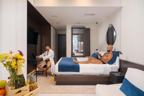 two men sitting on a bed in a hotel room at Fahana - Gay Men Only in Playa del Ingles