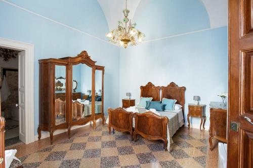 a bedroom with a bed and a mirror and a chandelier at Villa Degli Angeli in Nardò
