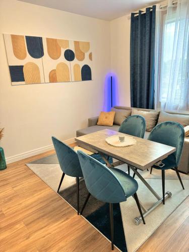 un salon avec une table, des chaises et un canapé dans l'établissement Appartement Cosy près de CDG, Astérix,JO, Paris, à Puiseux-en-France