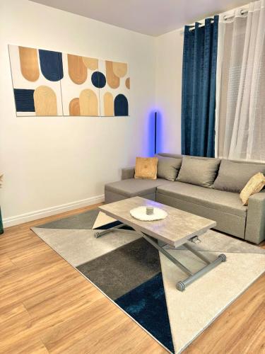 un salon avec un canapé et une table basse dans l'établissement Appartement Cosy près de CDG, Astérix,JO, Paris, à Puiseux-en-France