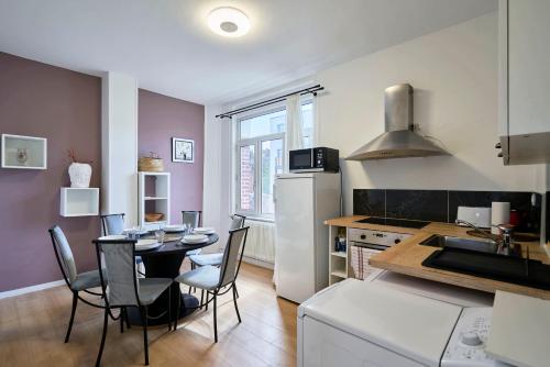 une cuisine et une salle à manger avec une table et des chaises dans l'établissement Maison Familiale Moderne Calme - Marcq-en-Barœul, à Marcq-en-Barœul