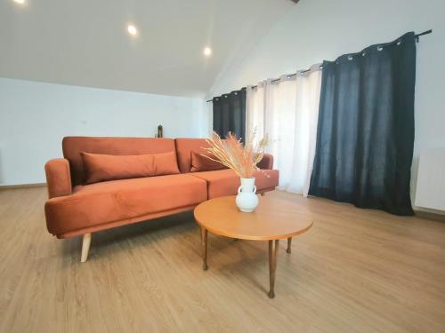 a living room with a couch and a table at Les Tilleuls - cnpe bugey - bases de loisirs - pérouges in Chazey-sur-Ain