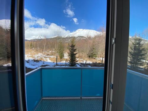 a view of a snowy mountain from a window at Apartmány Veternica v Bernarde in Smokovce