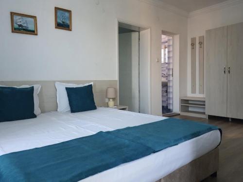 a large bed with blue pillows in a bedroom at Guest House Kolev - central in Nesebar