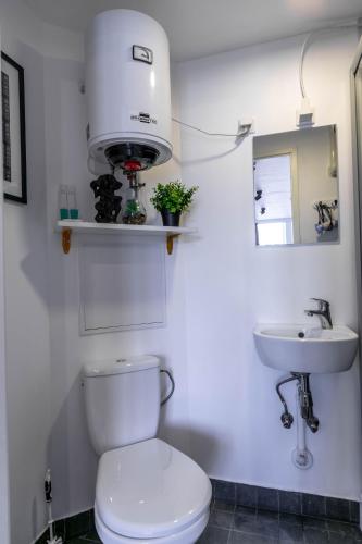 a white bathroom with a toilet and a sink at Apartments24 CITYBOX in Rakvere