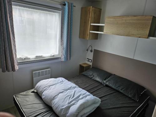 une petite chambre avec un lit et une fenêtre dans l'établissement Camping Le Bois Dormant, à Saint-Jean-de-Monts