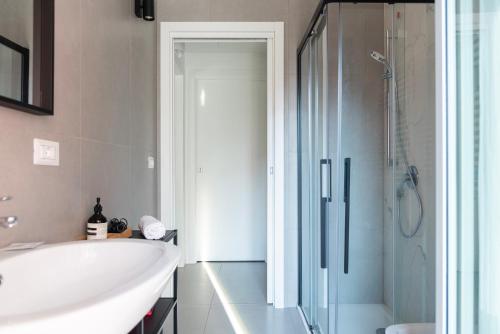 a bathroom with a tub and a sink and a shower at San Siro Fiera - Youhosty in Milan