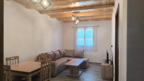 un salon avec un canapé et une table dans l'établissement Apartmani Stara kuca, à Žabljak