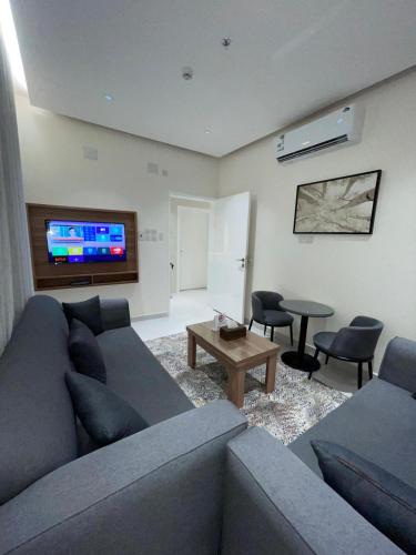 a living room with a couch and a table at شقق الورود بارك in Al Mikhlaf