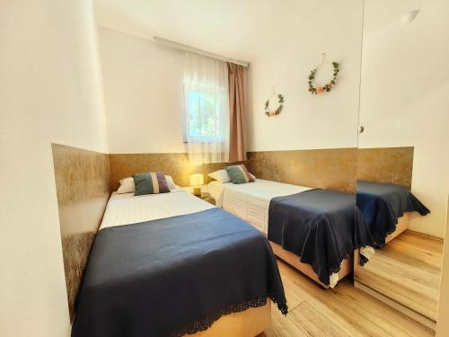 a bedroom with two beds and a window at Apartments Lea with pool 2 in Malinska