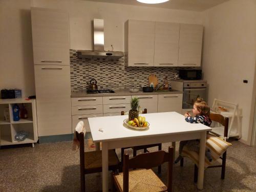 a child sitting at a table in a kitchen at Villa Marusia in Tollo