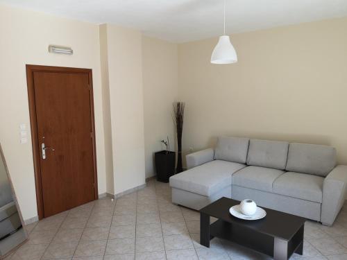 a living room with a couch and a table at Garden apartment 20m from the sea in Kírra