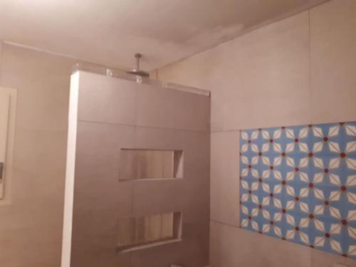 une salle de bain avec douche et un mur bleu et blanc dans l'établissement Belle maison piscine dans cadre verdoyant Vaucluse à 45min d'Aix et 55min de Marseille, à Puget