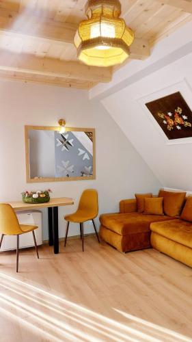 a living room with a couch and a table at Gordonówka Grand- blisko basenów termalnych Rezerwuj już dziś- nie przegap okazji! in Szaflary