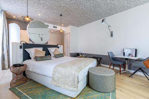 a bedroom with a bed with a mirror on the wall at Hotel Le Saint Gelais in Angoulême