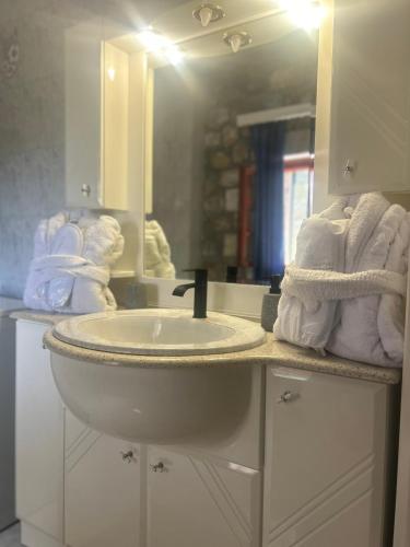 a bathroom with a sink and a mirror and towels at Terra Mani stone rental apartments in Gerolimenas