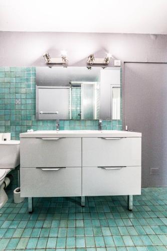 une salle de bain avec un lavabo et un miroir dans l'établissement La Pause des 6 - Maison Paisible, à Brive-la-Gaillarde