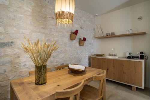 a dining room with a wooden table and a kitchen at BASSA MAINA Villas & Suites in Areopolis