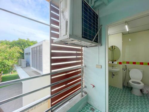a bathroom with a toilet and a window at Nicha Residence Hotel in Bangkok
