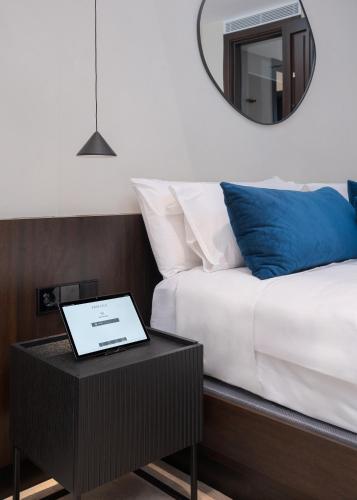 a bed with a table with a laptop on it at Fahana - Gay Men Only in Playa del Ingles