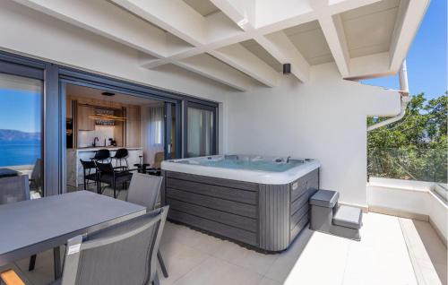 a bath tub in a room with a table and chairs at Beautiful Apartment In Novi Vinodolski in Novi Vinodolski